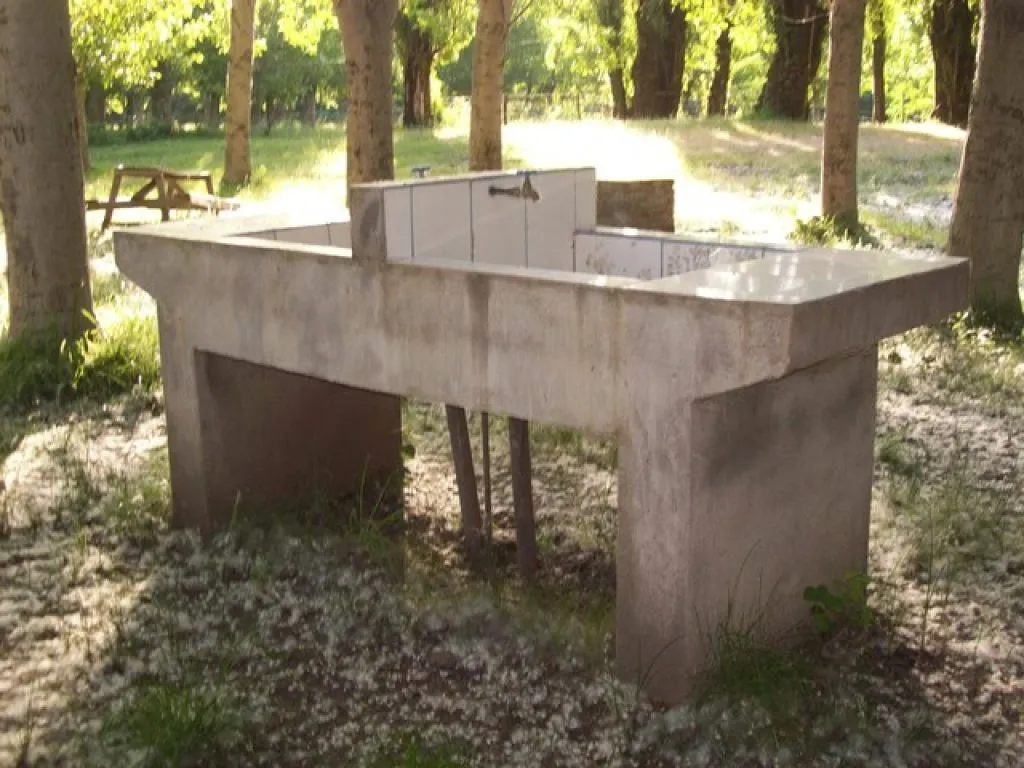Cabaña de madera con terraza cubierta y bancas, Camping Los Álamos