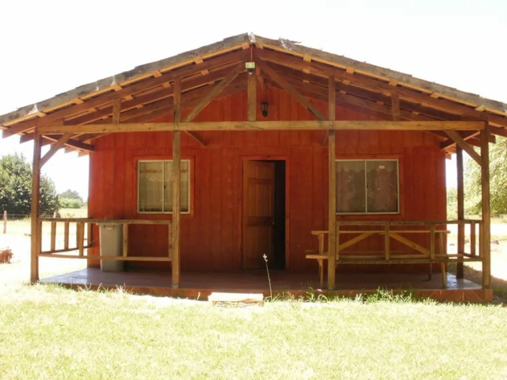 Dormitorio de cabaña con cama matrimonial y paredes de madera natural